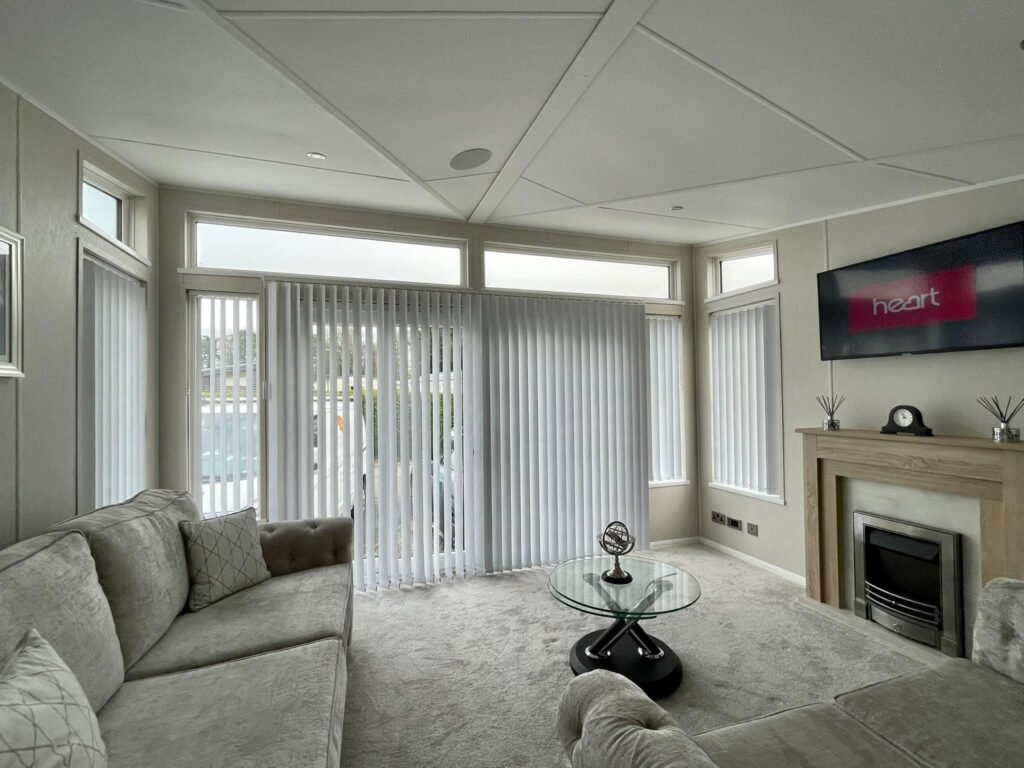 using blackout vertical blinds for living room with wall to wall carpets and upholstery by curtain shop